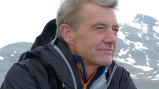 Headshot of Paul Rose with snowy mountains in the background.