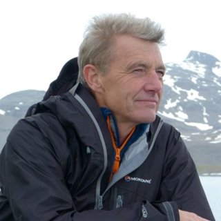 Headshot of Paul Rose with snowy mountains in the background.