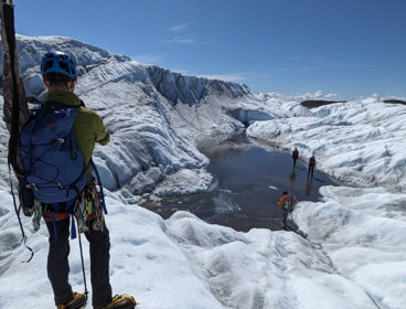 Grant recipient standing next to a glacial lake during fieldwork