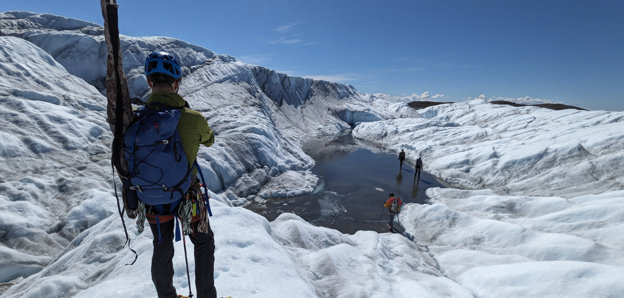 Grant recipient standing next to a glacial lake during fieldwork