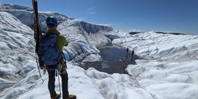Grant recipient standing next to a glacial lake during fieldwork