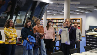 Eugene Rae showing a group of people items from the Collections in the Foyle Reading Room.