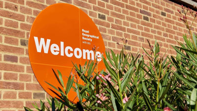 Round, orange welcome sign at the Royal Geographical Society.