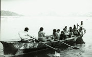Old photograph of a group of people rowing a boat.