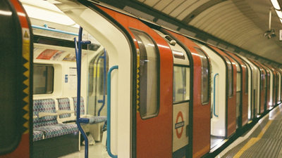 An empty  London underground Victoria line tube sits at a platform with its doors open.