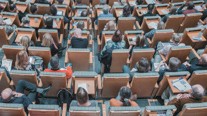 High-angle photograph of an audience seated in a modern lecture hall.