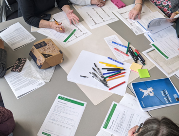Researchers working together at a table, brainstorming and writing notes 