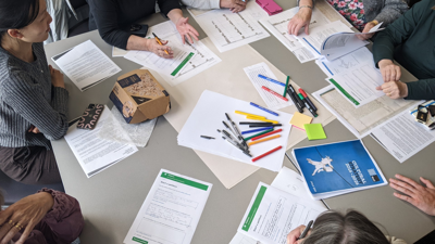 Researchers working together at a table, brainstorming and writing notes 