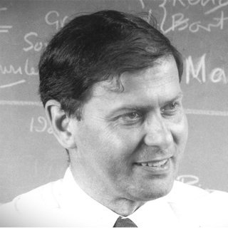 Peter Haggett in front of a chalkboard. The photo is black and white.