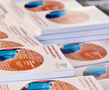 A stack of printed 2019 Annual International Conference programmes.