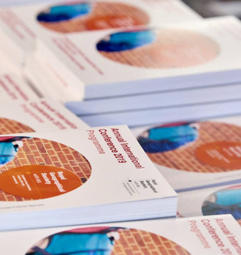 A stack of printed 2019 Annual International Conference programmes.