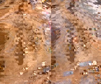 Aerial photography of dumper trucks and other industrial vehicles located in a mining area