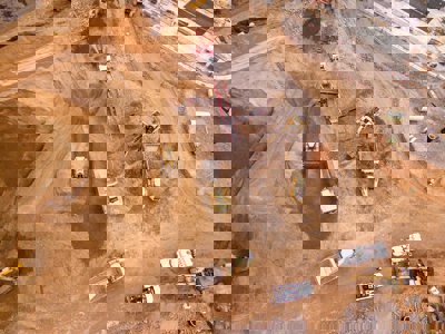Aerial photography of dumper trucks and other industrial vehicles located in a mining area