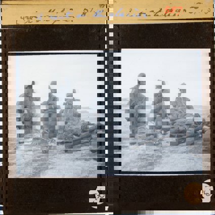 Historic black and white lantern slide showing three men wearing expedition clothing and with expedition equipment