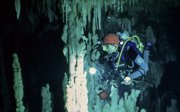 A man in scuba diving gear in an underwater cave.