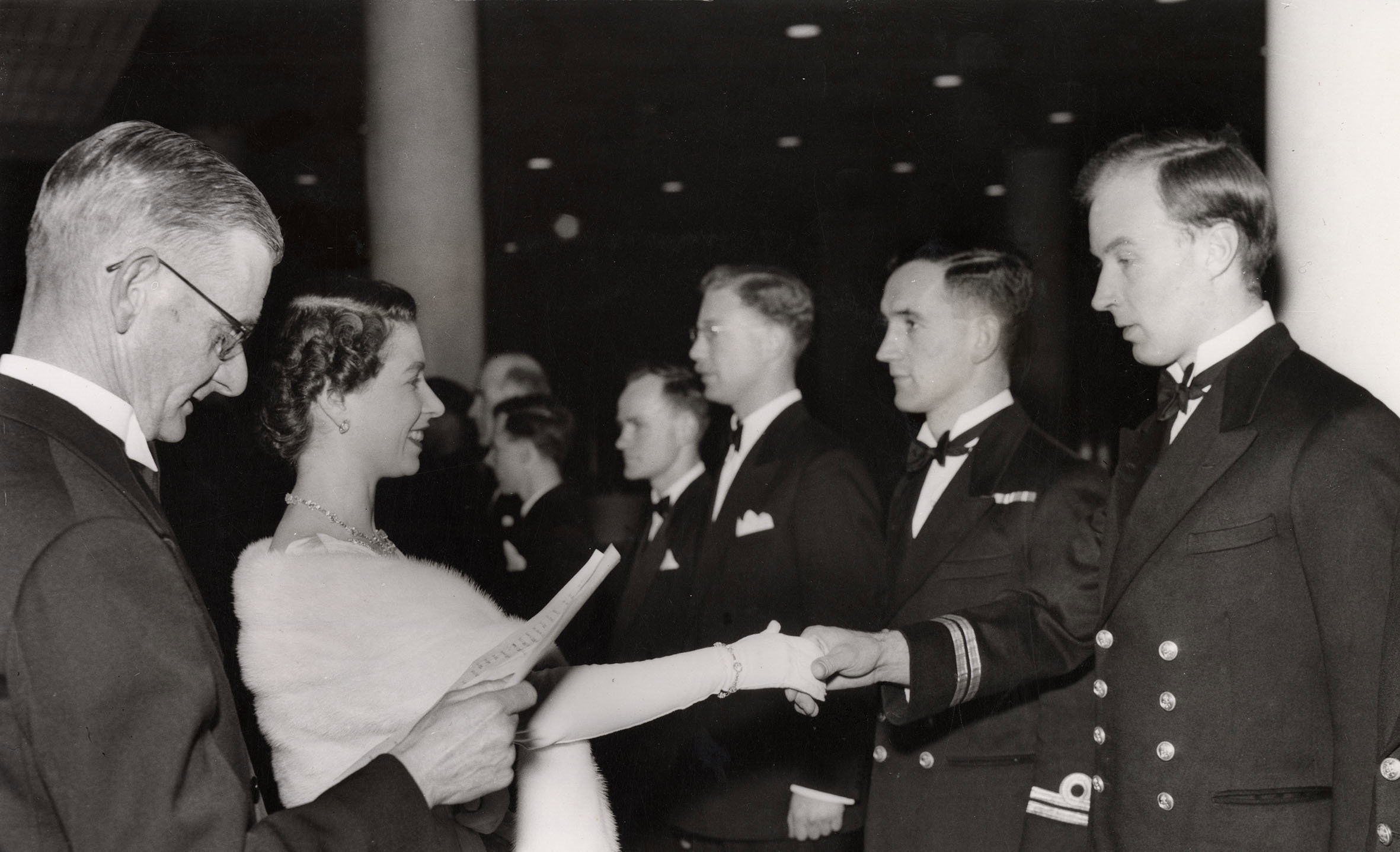 Queen Elizabeth II shakes hands with Lieutenant A. B. Erskine, R. N.