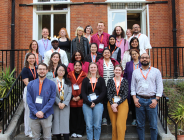 Delegates at the postgraduate mid-term conference 2025, standing on the stairs at the Terrace