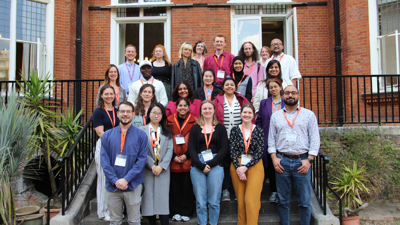 Delegates at the postgraduate mid-term conference 2025, standing on the stairs at the Terrace
