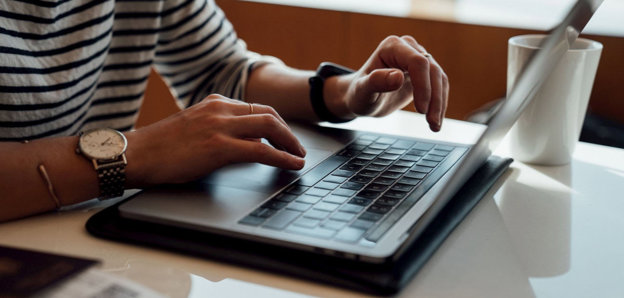 Person seated at the table using laptop.