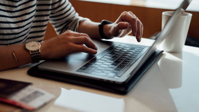 Person seated at the table using laptop.