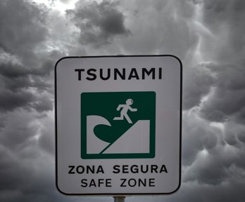 Tsunami warning sign in front of grey sky
