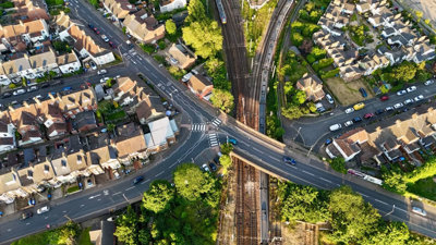 Roads crossing over a railway track near rows of houses.