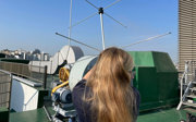 Madelaine Joyce conducting fieldwork in South Korea, holding a large antenna to carry out satellite records and image the weather systems.