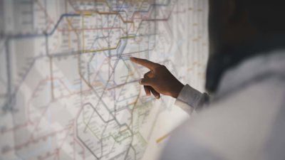 Finger pointing at London underground map.