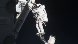 An astronaut in space outside of a space station.