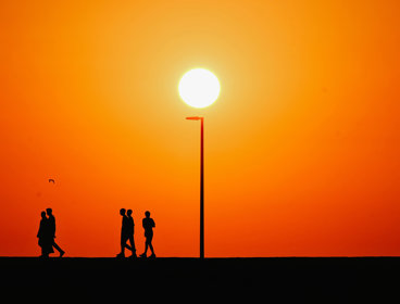 Orange sky with outline of people walking.