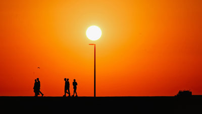 Orange sky with outline of people walking.