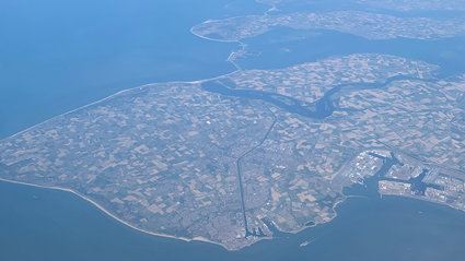 Aerial view of a peninsula with agricultural fields and scattered houses. 