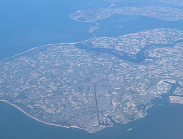 Aerial view of a peninsula with agricultural fields and scattered houses. 
