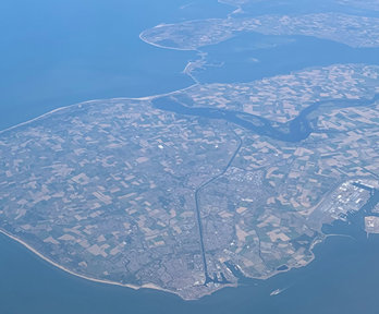 Aerial view of a peninsula with agricultural fields and scattered houses.