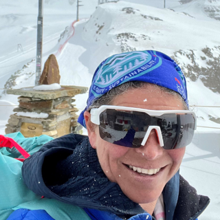 Anna Shekhdar in a snowy landscape wearing a bandana and ski glasses.