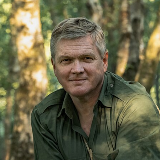 Headshot of Ray Mears in forest.