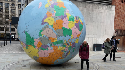 Academic Laura Pulido, stood next to large globe at the London School of Economics. 