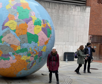 Academic Laura Pulido, stood next to large globe at the London School of Economics.