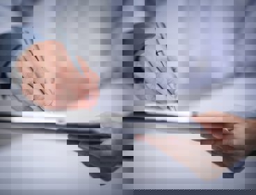 Hands holding a clipboard and writing something