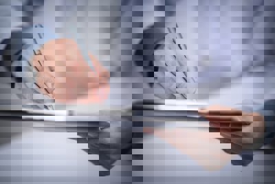 Hands holding a clipboard and writing something