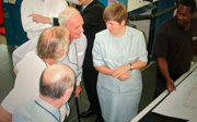 Four people in conversation standing next to a map.