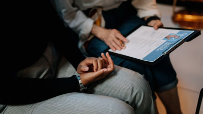 Two people with an application form on a clip board.