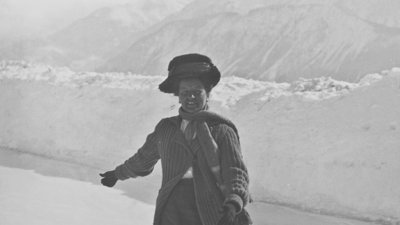 Fanny Bullock Workman ice-skating against mountain backdrop.