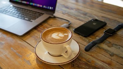 Coffee cup on desk with technology.