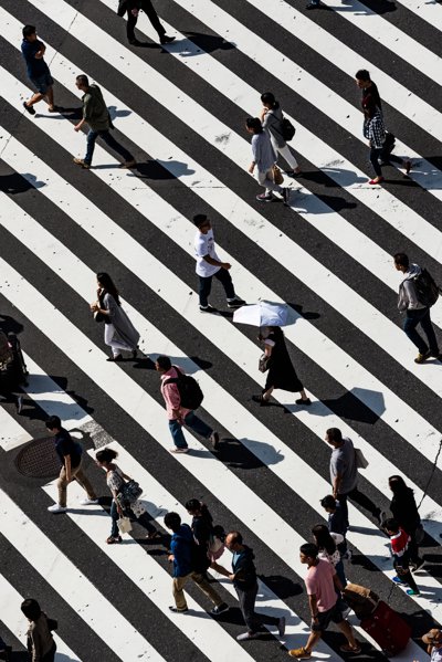 People crossing a zebra crossing coloured floor