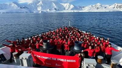 A group dressed in red on a boat, at sea in Antarctica.