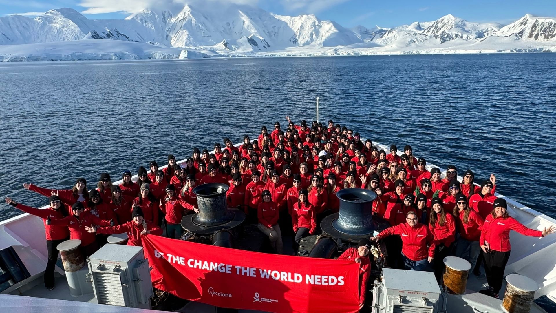 A group dressed in red on a boat, at sea in Antarctica.