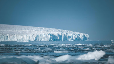 A glacier jutting out over frozen sea.