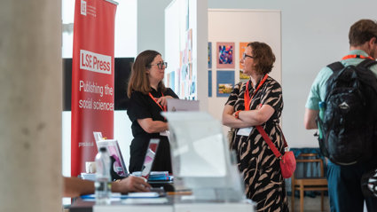 A delegate talks to a publisher's representative in the exhibitors' area