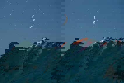 The moon at night over mountains